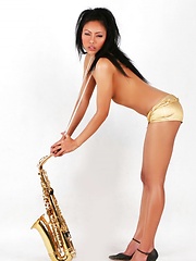 Janice in panties playing the saxophone topless